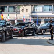 Three black large SUVs lined up under shelter drop-off zone.