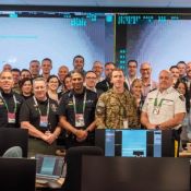 Large group photo of professional team in an office meeting room.