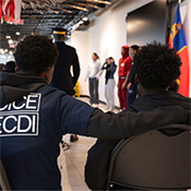 Student with a Junior DICE ECDI shirt sitting with his arm around another student during an RCMP presentation at the Canadian Police College.