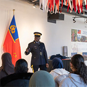 An RCMP officer speaks to a group of seated students in a training room at the Canadian Police College.