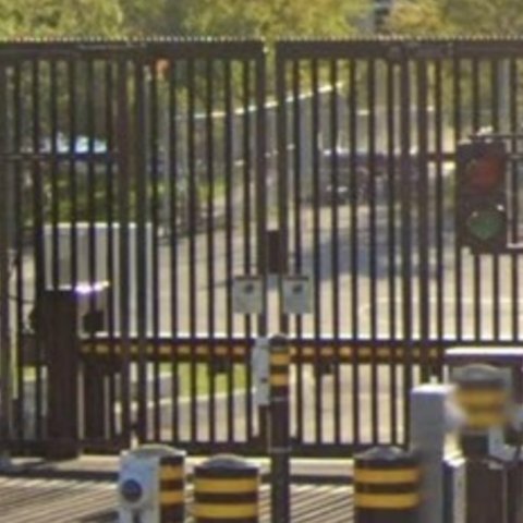 Figure depicting a closed gate with a green and red traffic light