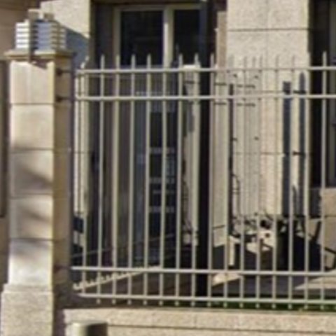 Figure depicting a fence with vertical metal fencing bars anchored to concrete