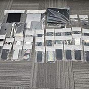 34 phones, tablets and other electronic communications devices seized by the RCMP and arranged in evidence bags after the search of the home used by Mansouri and Alouah