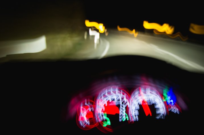 View from inside a vehicle at night with blurred lights suggesting impaired or reduced visibility.
