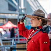 An officer in Red Serge salutes during the national anthem.
