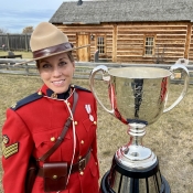 An officer in Red Serge poses with the Grey Cup.