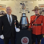 The Keeper of the Grey Cup and a officer in Red Serge pose with the Grey Cup.