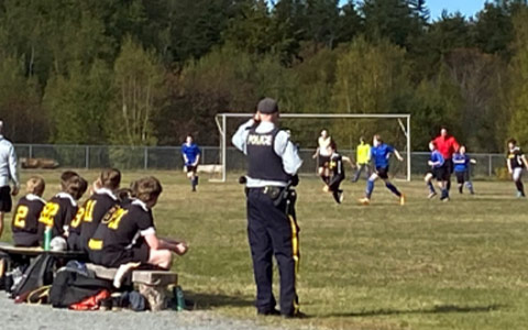 Shawn Galbraith stands on the edge of a soccer field in uniform.