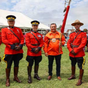 Prince Edward Island <abbr>RCMP</abbr> members in red serge stand with Mi'kmaq member and Canadian Senator Brian Francis at the Abegweit Pow Wow.