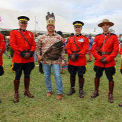 Prince Edward Island <abbr>RCMP</abbr> members in red serge stand with Abegweit First Nations Chief Roddy 