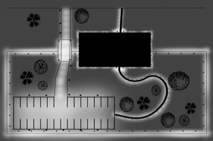A facility with lighting illuminating the perimeter fencing, gated vehicle entry, pedestrian walkway, parking area and the building