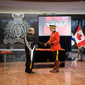 Keptin Donald Julien shakes hands Brian Brennan, Commanding Officer of the Nova Scotia RCMP>
