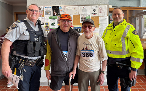 Two RCMP officers pose for a photo with two run participants.