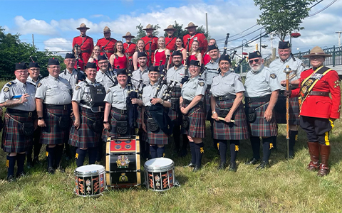 The RCMP Pipes and Drums Band poses for a group photo.