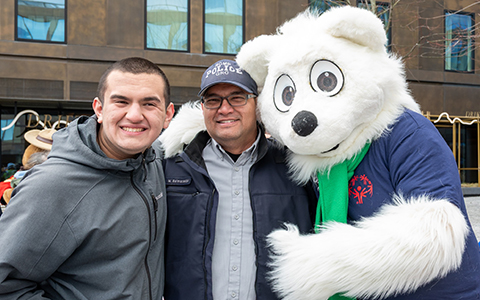 And RCMP officer is flanked by his son and a mascot.
