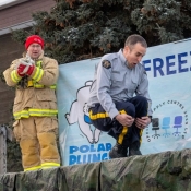 An RCMP member does a canon ball into a large pool