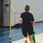 A cadet runs through some green pylon obstacles.