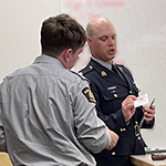 An instructor presents a Silent Partner card to a cadet.