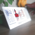 Member in red serge placing a Silent Partner Card on a table.