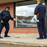A cadet takes pictures of his partner properly handling, storing and labelling the evidence.