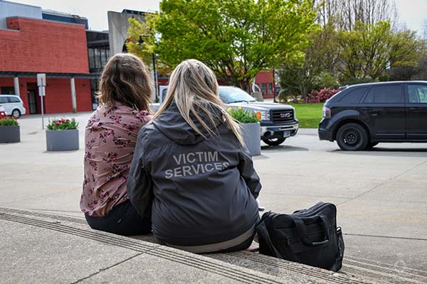 Victim services member sitting beside a woman