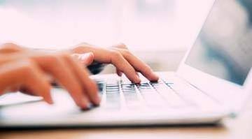 hands typing 'report a crime' on a keyboard