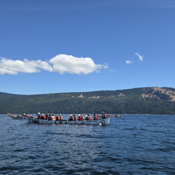 Photo of one of 3 RCMP canoes paddling alongside other participating canoes during the final leg of the Pulling Together canoe journey from Mill Bay to Cowichan Bay off the coast of Vancouver Island.