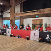 Eight Senior leaders of the RCMP in ceremonial dress sit at the head table with Cowichan Tribes Chief Cindy Daniels listening to Elders share teaching and stories.