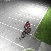 Photo of suspect # 2 on bike wearing a red hoodie and baseball hat