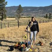 Alix Legouffe stands by a roadside memorial to her brother, Buddy Rhodes