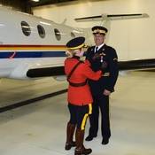 Chief Superintendent Ellis pinning the medal on RCMP Pilot, Special Constable Allen Predovic. An RCMP plane can be seen in the background.