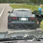 A green Jaguar with its driver at roadside, seen through the dashboard of a BC Highway Patrol cruiser. The driver was stopped for speeding and was then found to be impaired