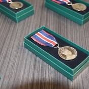 Several King Charles III Coronation Medals displayed in boxes on a table.