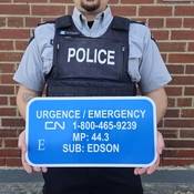 Alberta RCMP officer holds CN Emergency sign.