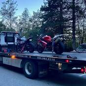 Two motorcycles sitting on the back of a tow-truck on their way to a seven-day impound for excessive speeding on the Sea to Sky Highway