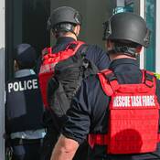 One police and two Rescue Task Force members entering through a door.