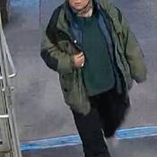 Photo of woman with hair pulled back, green and black jacket with black pants