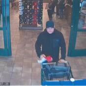Suspect pushing shopping cart walking out front door of Cabelas