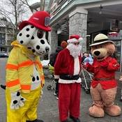 A photo, from the 2024 Whistler Emergency Services Holiday Food and Toy Drive, of Fire Officer Sparky, Santa Claus, and Safety Bear standing together