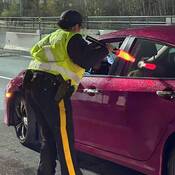 Police officer checking driver for impairment