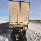 The stopped tractor-trailer unit with the seized items behind it
