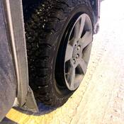 A close-up of a vehicle tire partially detached from its rim, illustrating the dangers of low tire pressure in extreme cold.