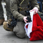 Green police uniform with red and white bag and a dog stuffed animal