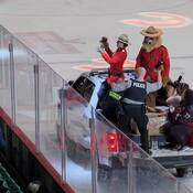 Cst Rissanen and Cst NEUSTAETER on the ice throwing collectible IPS sasquatches to the fans