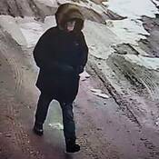 Photo of man wearing black winter coat wearing glasses, and has grey facial hair