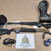 2 x loaded shotguns, a dirt bike boot, a hat and headphones