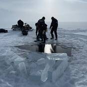RCMP Underwater Recovery Team specialized ice divers about to enter water at Charlotte Lake.