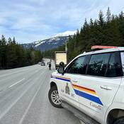 RCMP member walking toward Semi truck during roadside stop.
