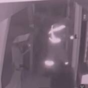 A surveillance photo of a suspect breaking into a building.