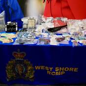 Table displaying seized drugs, replica handguns, knifes and cash seized by officers.
